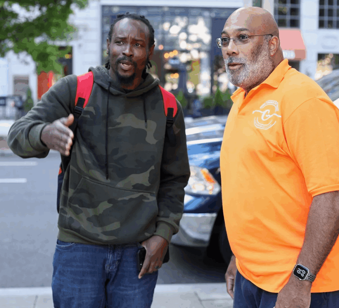 Two men talking on a city street.